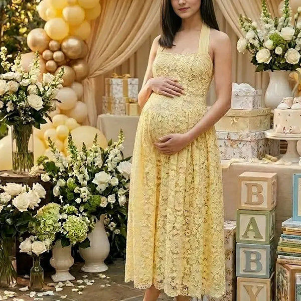 Pregnant woman wearing yellow lace halter maternity maxi dress at baby shower garden party