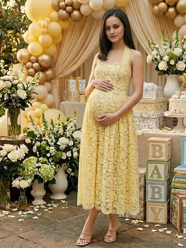 Pregnant woman wearing yellow lace halter maternity maxi dress at baby shower garden party