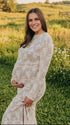 Pregnant woman wearing  elegant white maternity maxi dress for maternity photoshoot outdoors