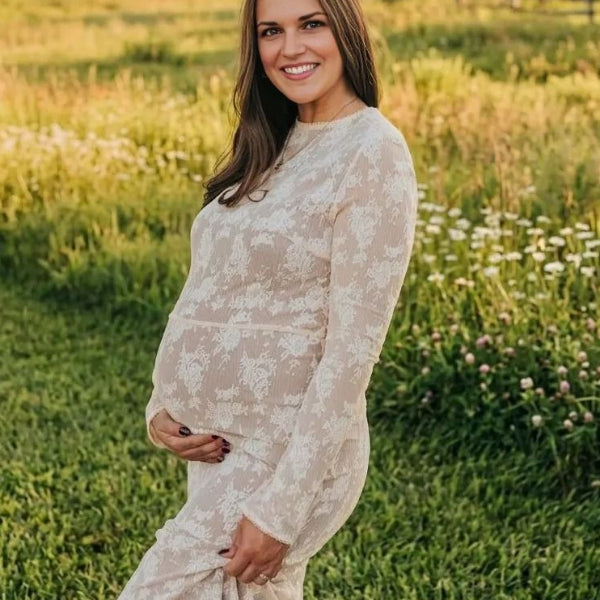 Pregnant woman wearing  elegant white maternity maxi dress for maternity photoshoot outdoors