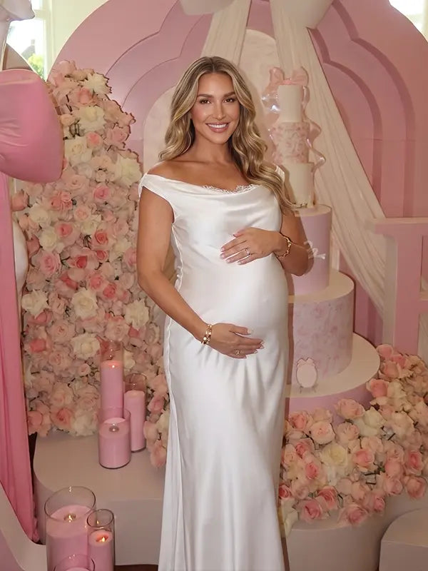 white off shoulder cowl neck maternity gown with open back detail and flowing silhouette