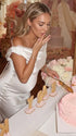 white off shoulder cowl neck maternity gown with open back detail and flowing silhouette