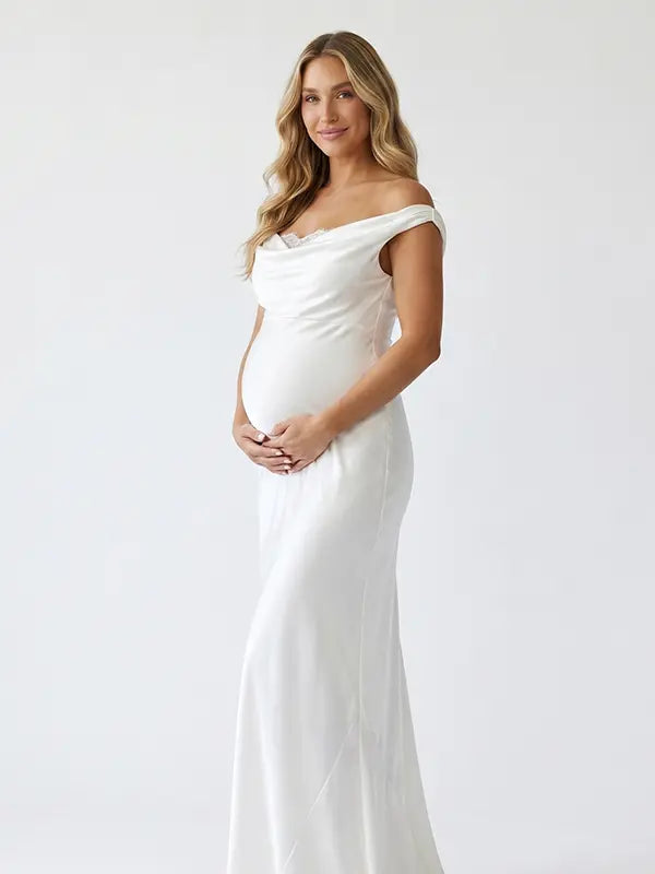 white off shoulder cowl neck maternity gown with open back detail and flowing silhouette