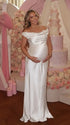white off shoulder cowl neck maternity gown with open back detail and flowing silhouette