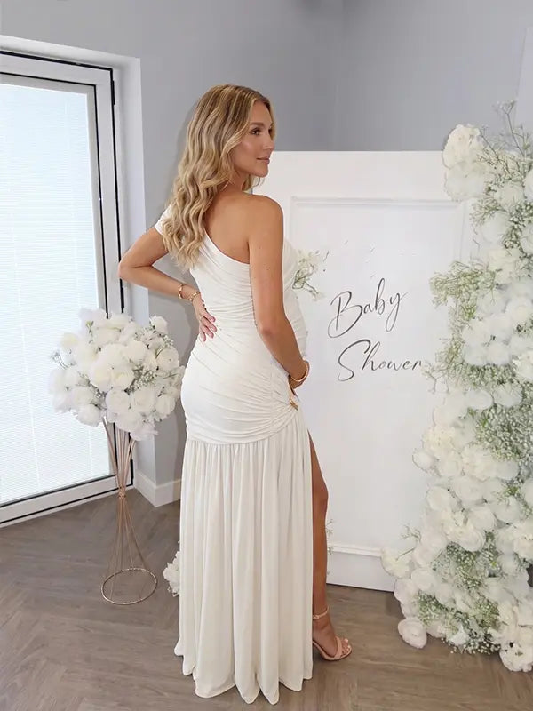 White one shoulder goddess maternity gown with ruched bodice and flowing mesh skirt