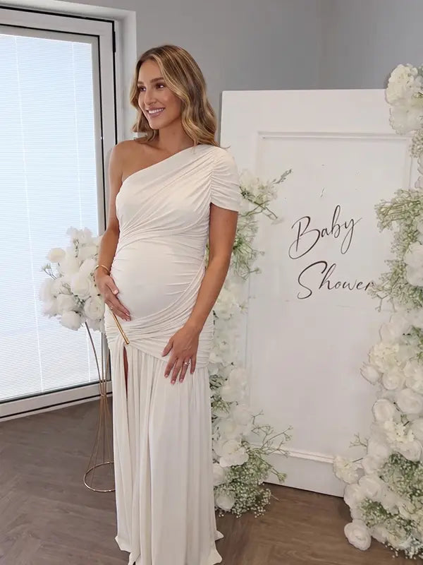 White one shoulder goddess maternity gown with ruched bodice and flowing mesh skirt