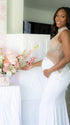 A white rhinestone illusion mesh maternity mermaid maxi dress for luxury maternity photoshoot, baby shower, editorial portrait, and pregnancy announcement.