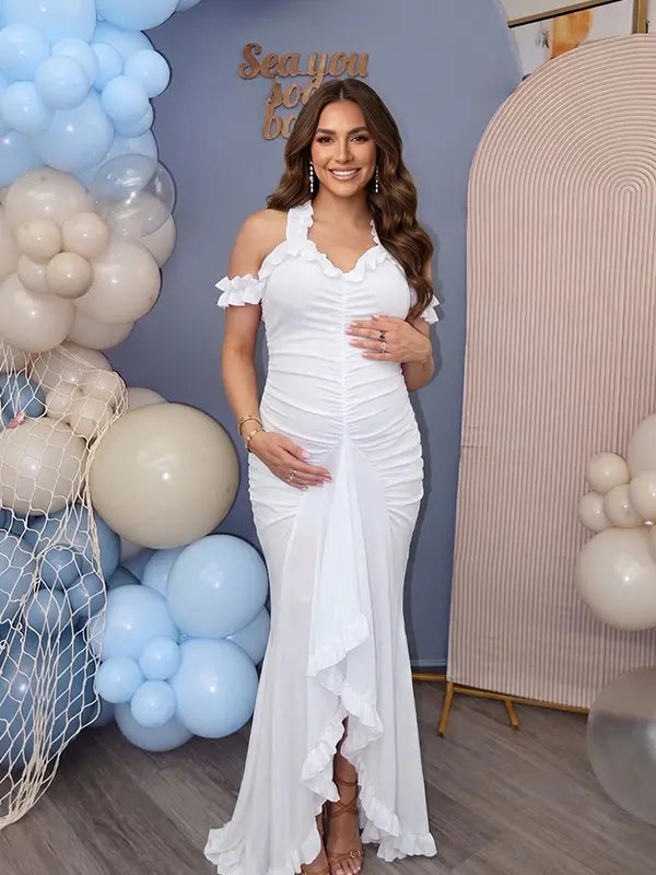 White ruffle halter maternity maxi dress with flattering ruching and high-low hem for baby shower photoshoot